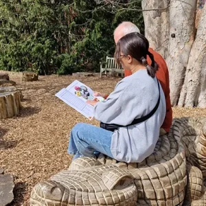 Sitting on a woooden crocodile seat enjoying a puzzle together in the garden